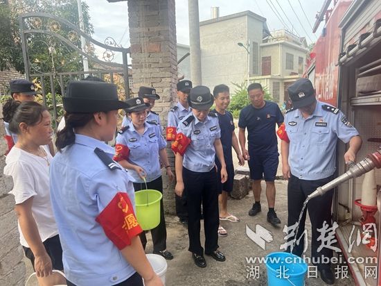 民輔警跟隨消防水車作業(yè)，通過肩挑手提的方式將清水送入行動(dòng)不便的老年、殘障村民的家中（通訊員 李麗君 攝） (3).jpg.jpg